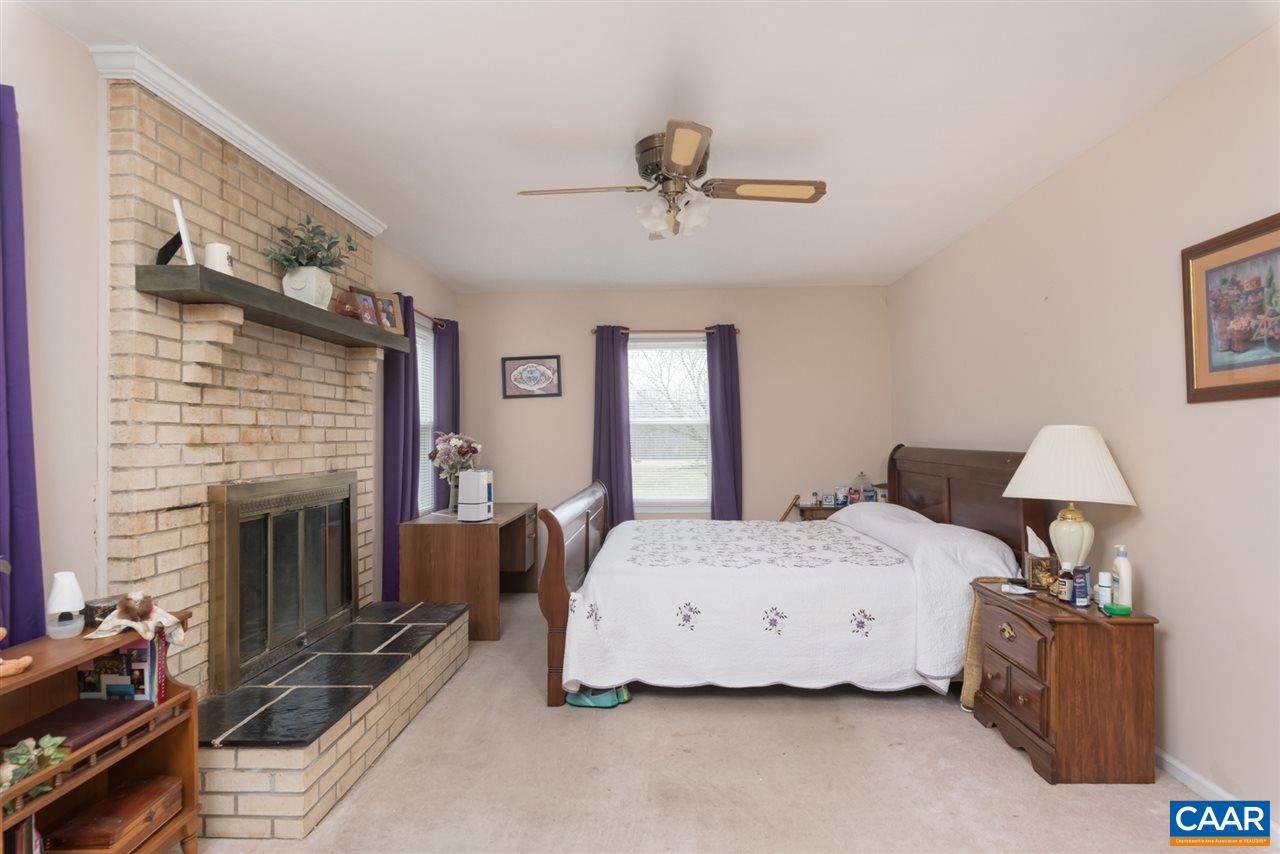706 Zion Road Zion Crossroads, VA 22942 - Photo 11 of 38 a spacious bedroom with a bed and a fireplace