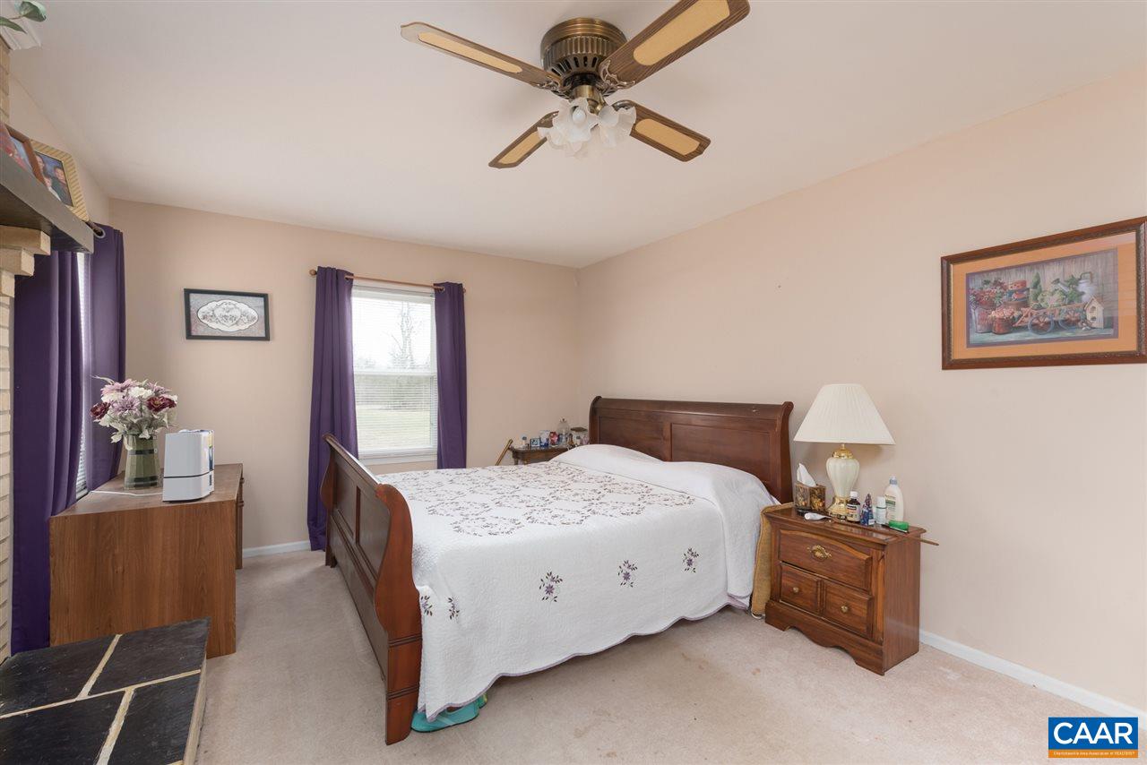 706 Zion Road Zion Crossroads, VA 22942 - Photo 13 of 38 a bedroom with a bed and a chandelier