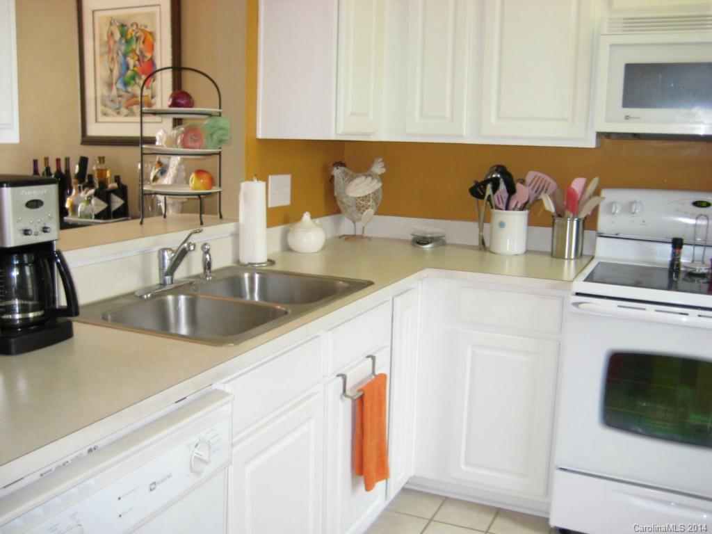 334 Sugar Ridge Court, Unit 102 Fort Mill, SC 29708 - Photo 7 of 18 a kitchen with stainless steel appliances granite countertop a sink dishwasher and cabinets with wooden floor