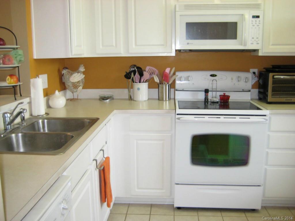 334 Sugar Ridge Court, Unit 102 Fort Mill, SC 29708 - Photo 8 of 18 a kitchen with stainless steel appliances granite countertop a sink a stove and microwave