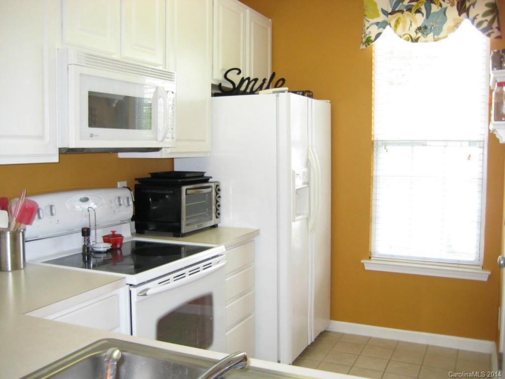 334 Sugar Ridge Court, Unit 102 Fort Mill, SC 29708 - Photo 9 of 18 a kitchen with a refrigerator and a stove top oven