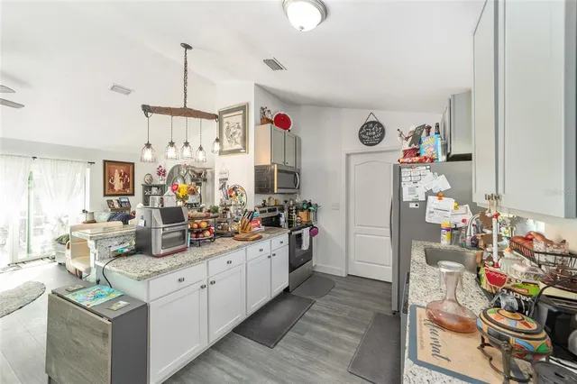 a kitchen with stainless steel appliances kitchen island granite countertop living room