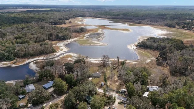 a view of a dry yard with wooden fence