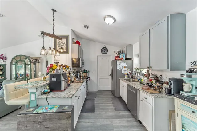 a kitchen filled with stainless steel appliances kitchen island granite countertop lots of clutter and stainless steel appliances