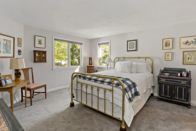 a bedroom with a bed and a table in it with window