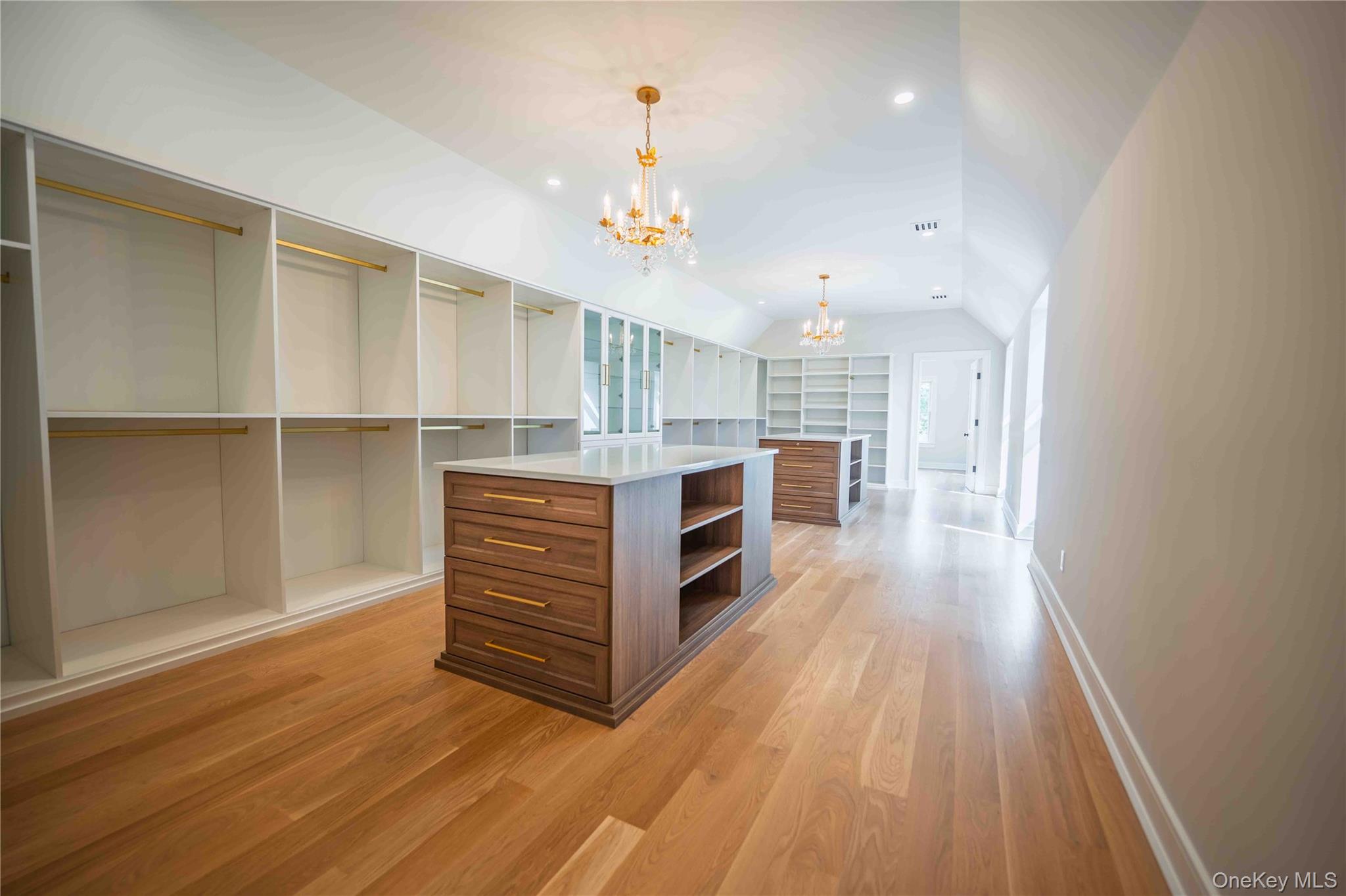 106 Cove Road Asharoken, NY 11768 - Photo 28 of 46 Walk in closet with a chandelier, vaulted ceiling, and light wood-style floors