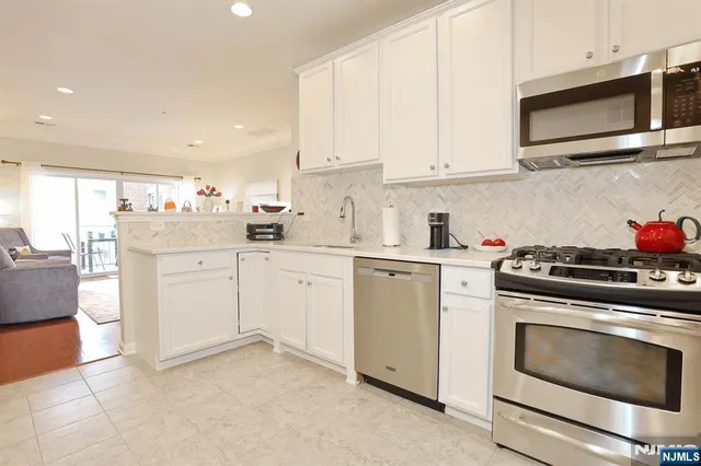 a kitchen with white cabinets stainless steel appliances and sink