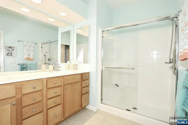 a bathroom with a shower sink vanity and mirror