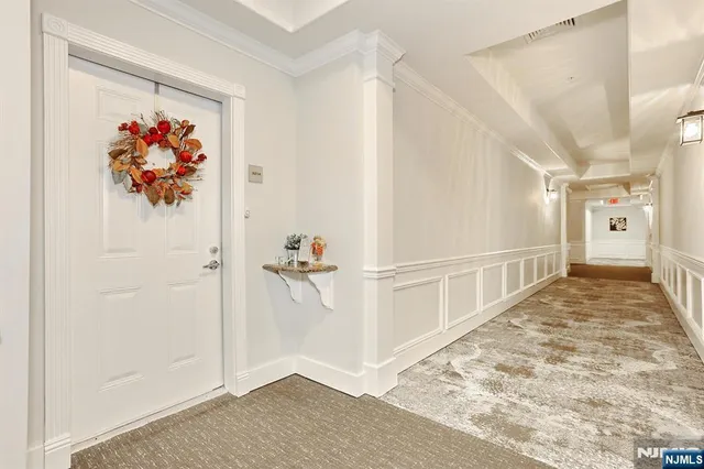 a view of a hallway to a room with painting on the wall