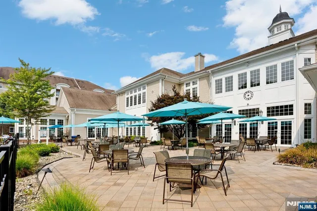 a patio with a table and chairs under an umbrella