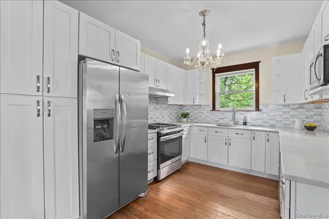 a kitchen with granite countertop a refrigerator sink and cabinets