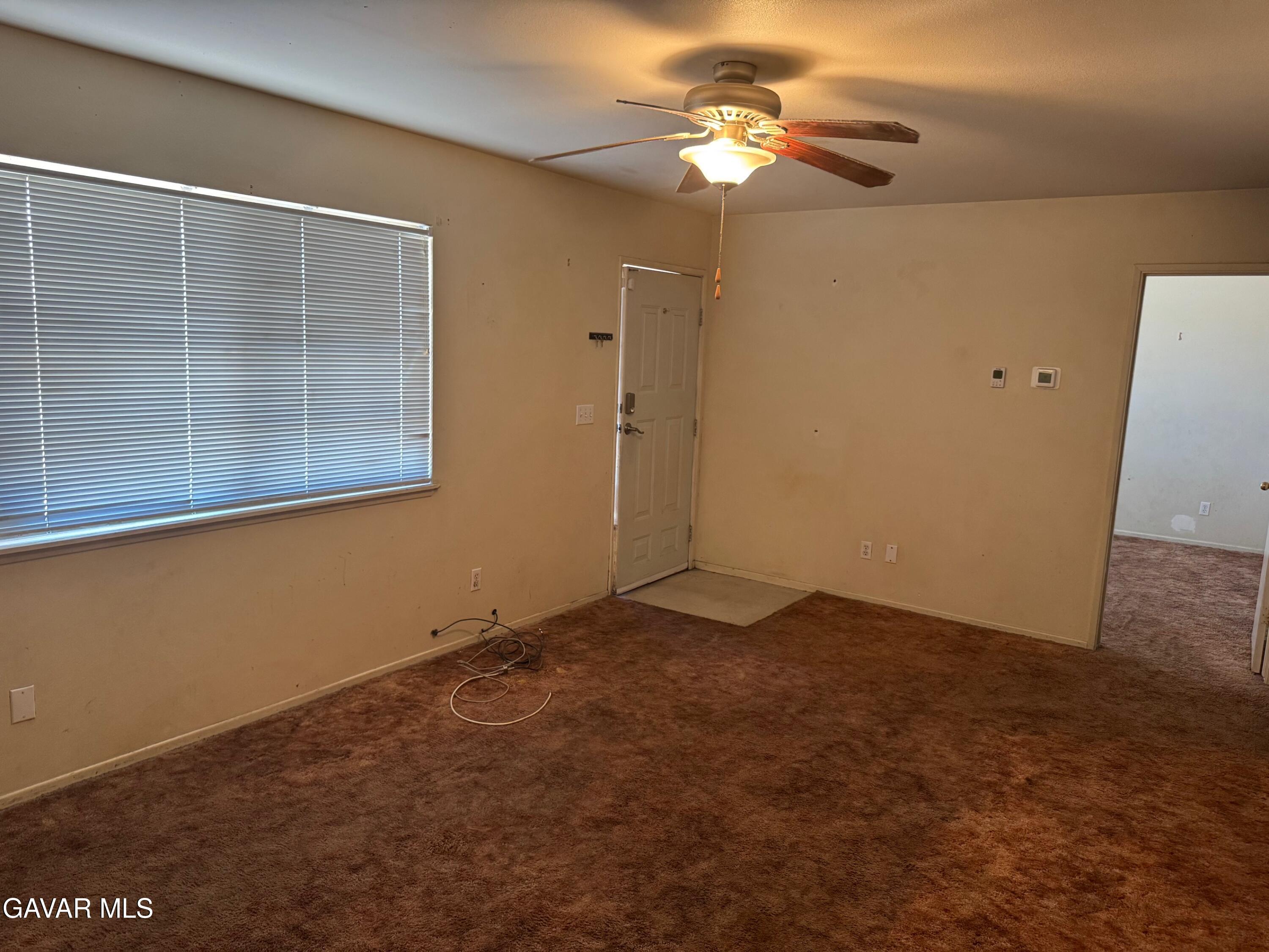 1105 South McCall Street Ridgecrest, CA 93555 - Photo 3 of 12 an empty room with windows and fan