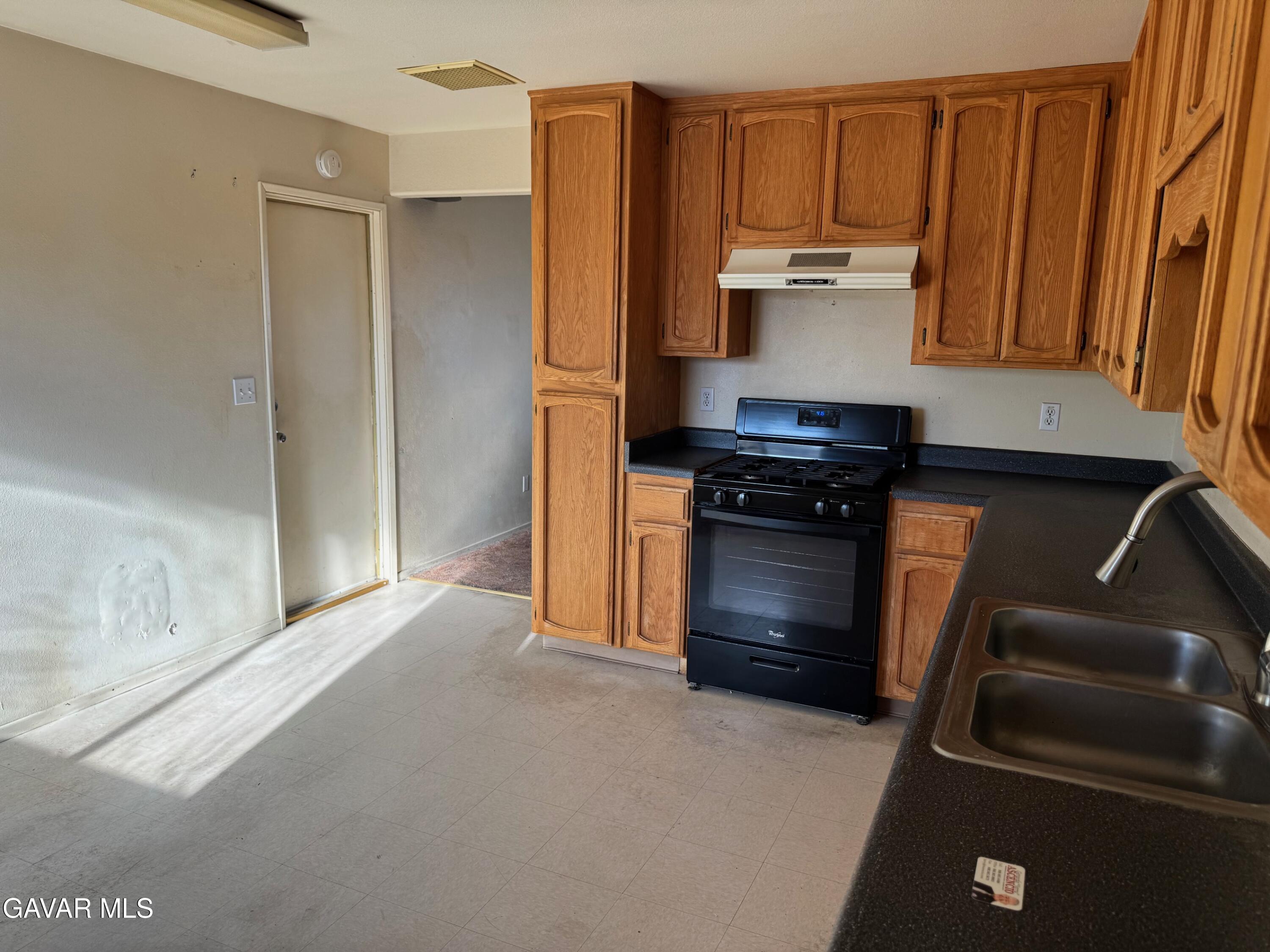 1105 South McCall Street Ridgecrest, CA 93555 - Photo 6 of 12 a kitchen with a refrigerator and a stove
