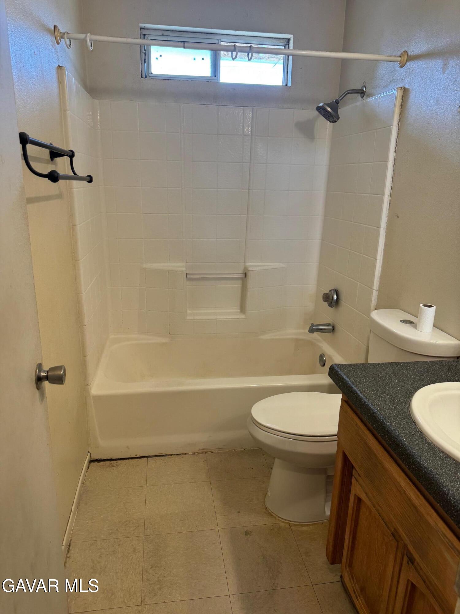 1105 South McCall Street Ridgecrest, CA 93555 - Photo 7 of 12 a bathroom with a granite countertop bathtub shower sink vanity and toilet