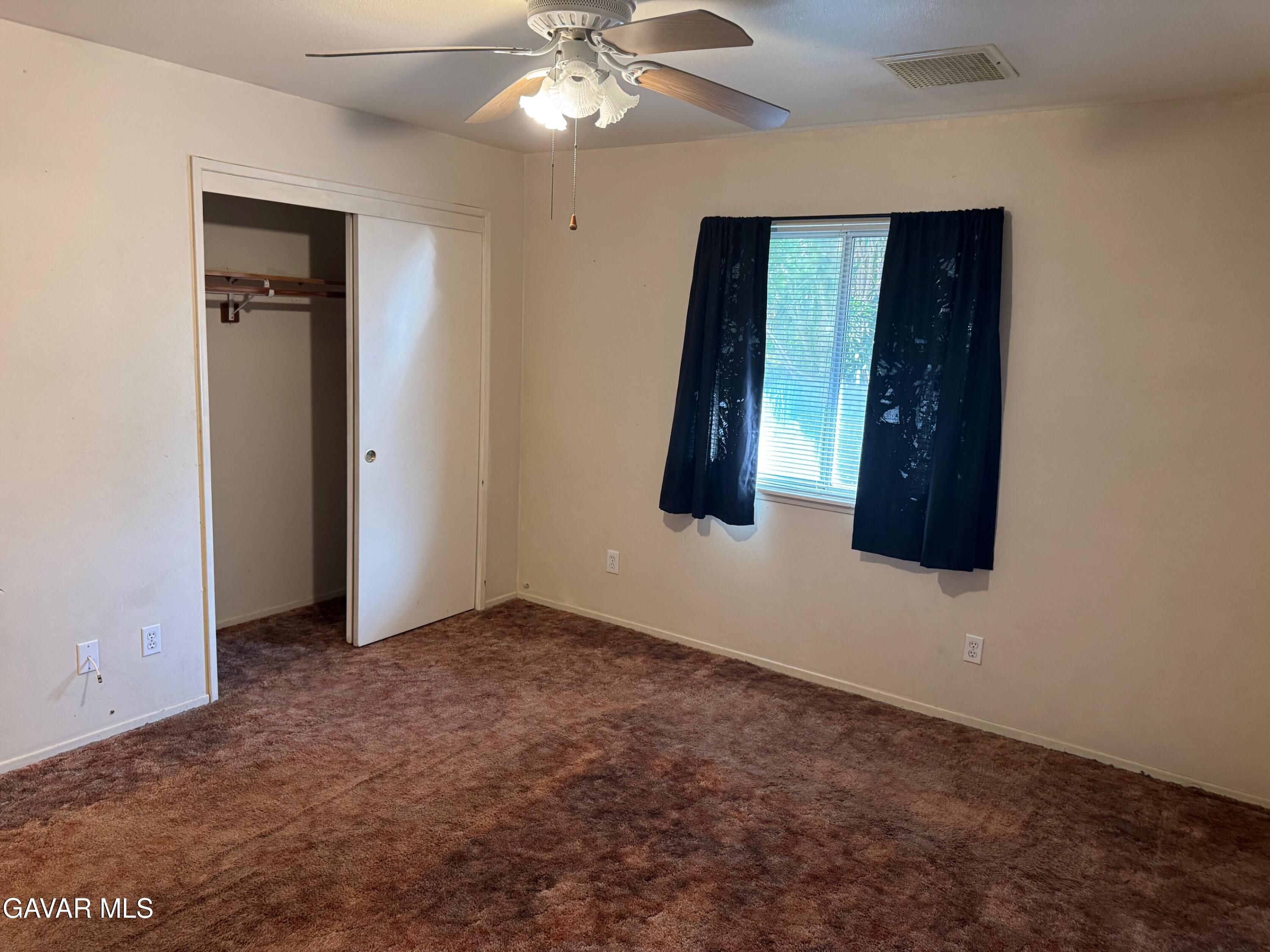 1105 South McCall Street Ridgecrest, CA 93555 - Photo 9 of 12 an empty room with windows and fan