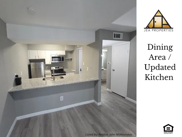 a view with kitchen island a sink wooden floor and living room view
