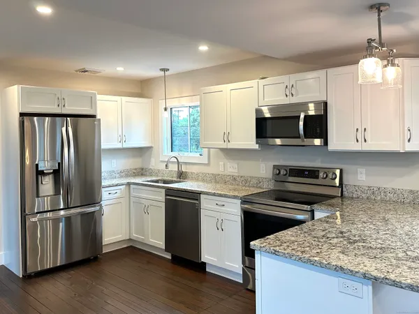 a kitchen with stainless steel appliances granite countertop a refrigerator stove microwave and sink