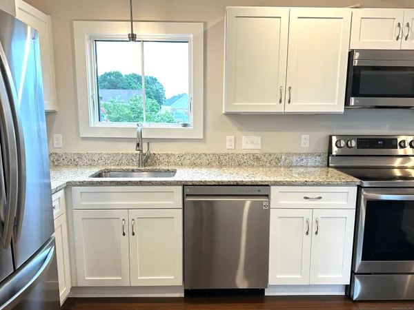 a kitchen with stainless steel appliances granite countertop a sink stove and cabinets
