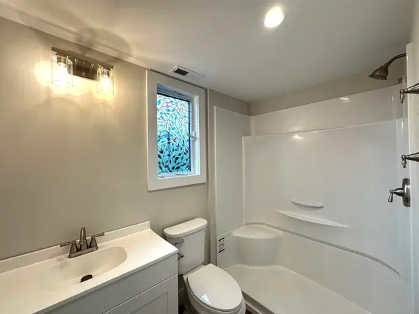 a bathroom with a sink a toilet and shower