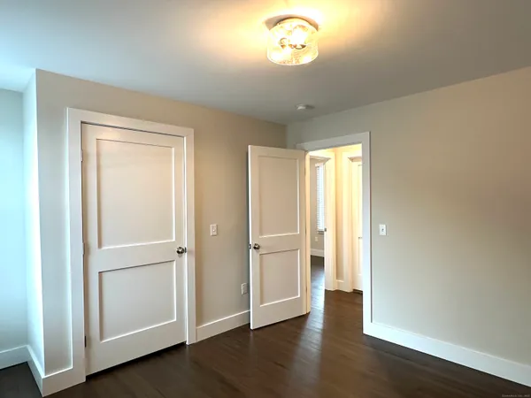 a view of empty room with wooden floor and window