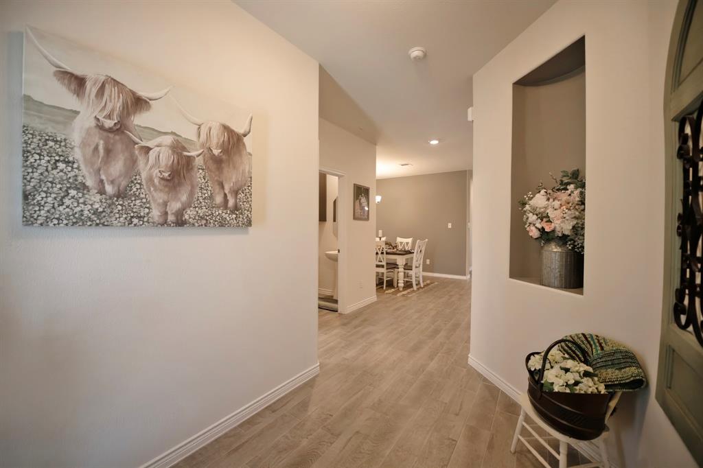 3970 Sidney Lane Forney, TX 75126 - Photo 4 of 25 a view of a hallway with wooden floor and a living room