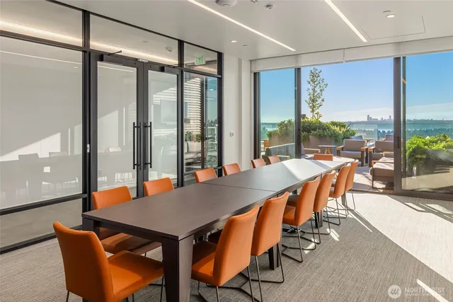 a dining room with furniture and a floor to ceiling window