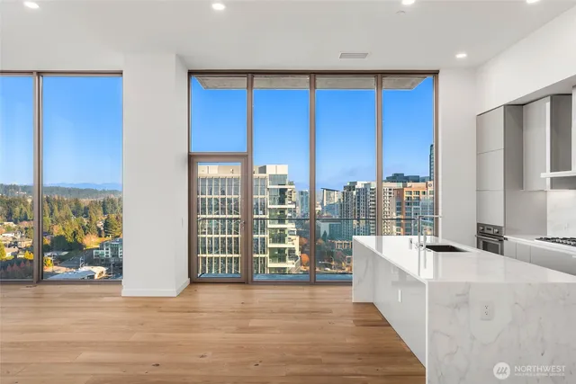a view of a kitchen with kitchen island granite countertop a large window and a couch