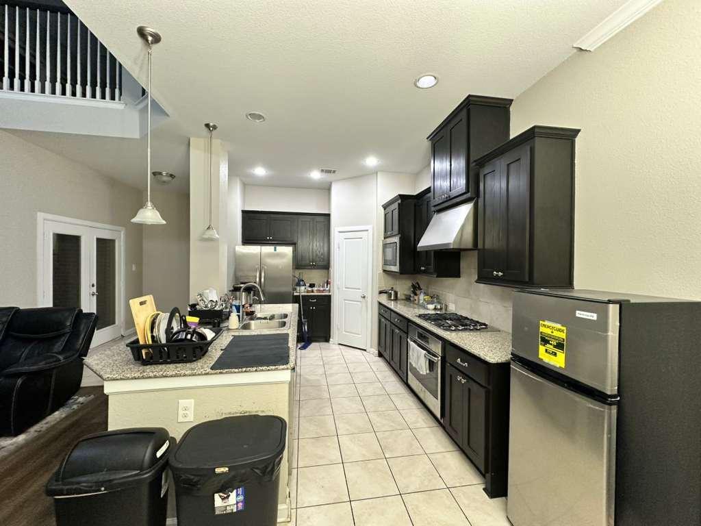 6655 DeLeon Street Irving, TX 75039 - Photo 3 of 10 a kitchen with stainless steel appliances kitchen island granite countertop a refrigerator and a stove top oven