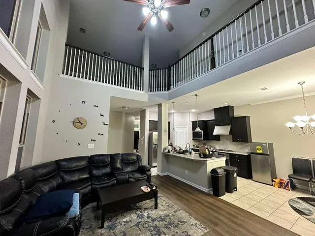 a living room with stainless steel appliances kitchen island granite countertop furniture a rug and a window