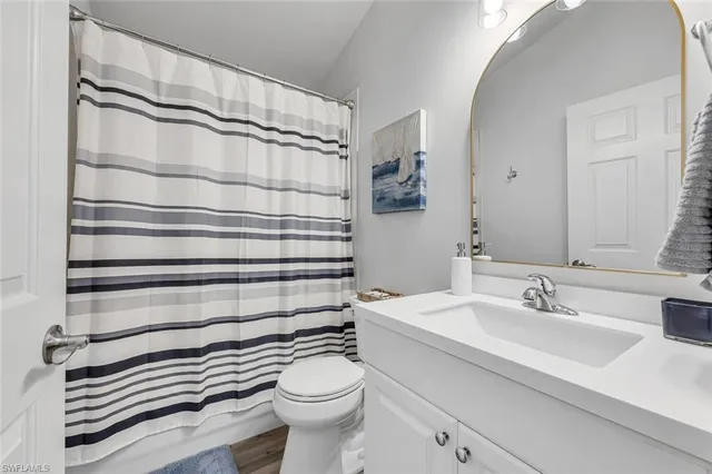 a bathroom with a sink a toilet and shower curtain