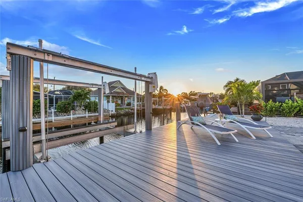 a view of a patio with dining table and chairs with wooden floor and fence