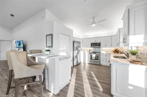 a living room with stainless steel appliances kitchen island furniture and a view of kitchen