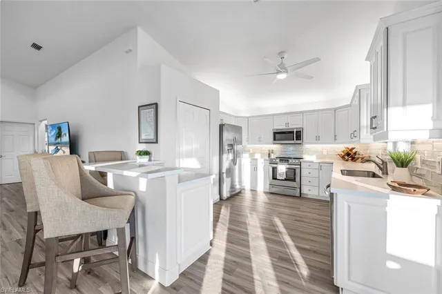 a living room with stainless steel appliances kitchen island furniture and a view of kitchen