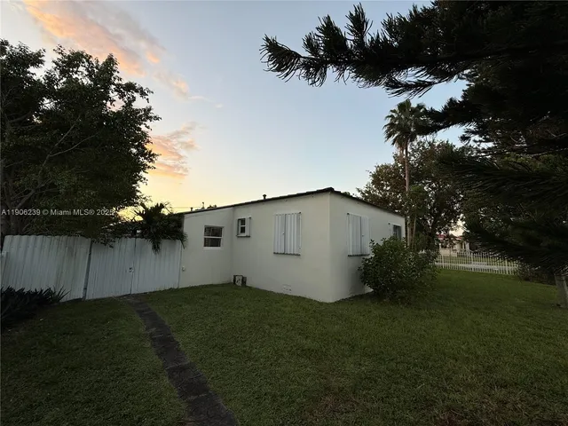 a view of a house with backyard and sitting area