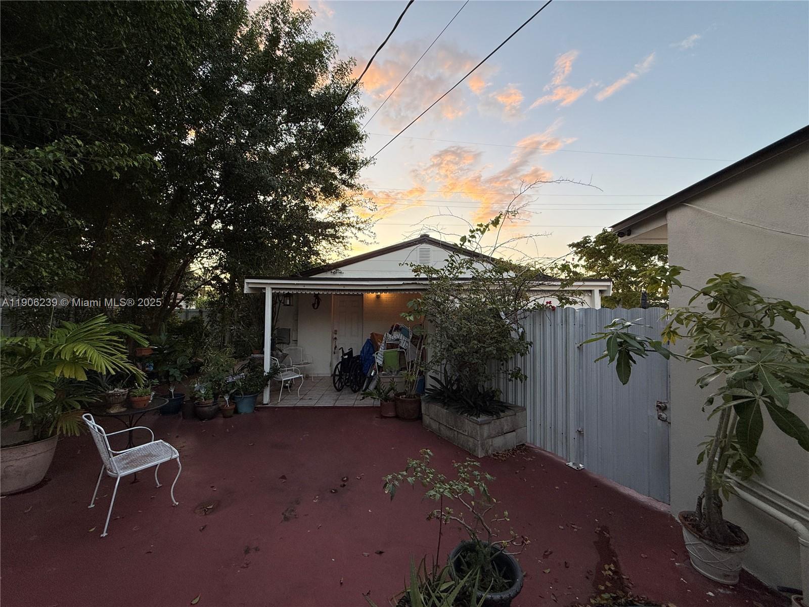 6300 Northwest 2nd Street Miami, FL 33126 - Photo 15 of 26 a backyard of a house with table and chairs with wooden fence