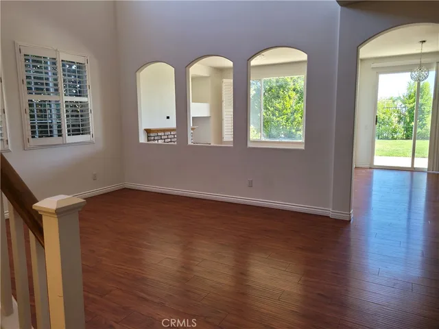 a view of room with two windows and wooden floor