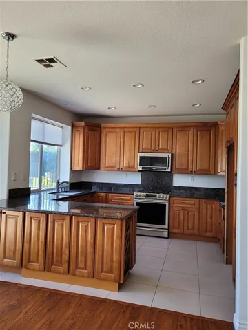 a kitchen with granite countertop a stove top oven and cabinets