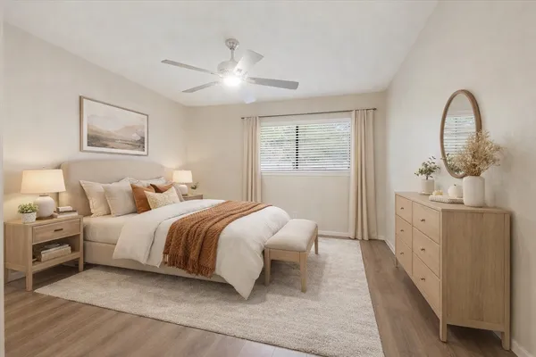 a spacious bedroom with a bed and a dresser