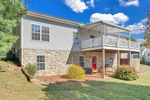 a view of a patio with table and chairs and couches with wooden floor and fence