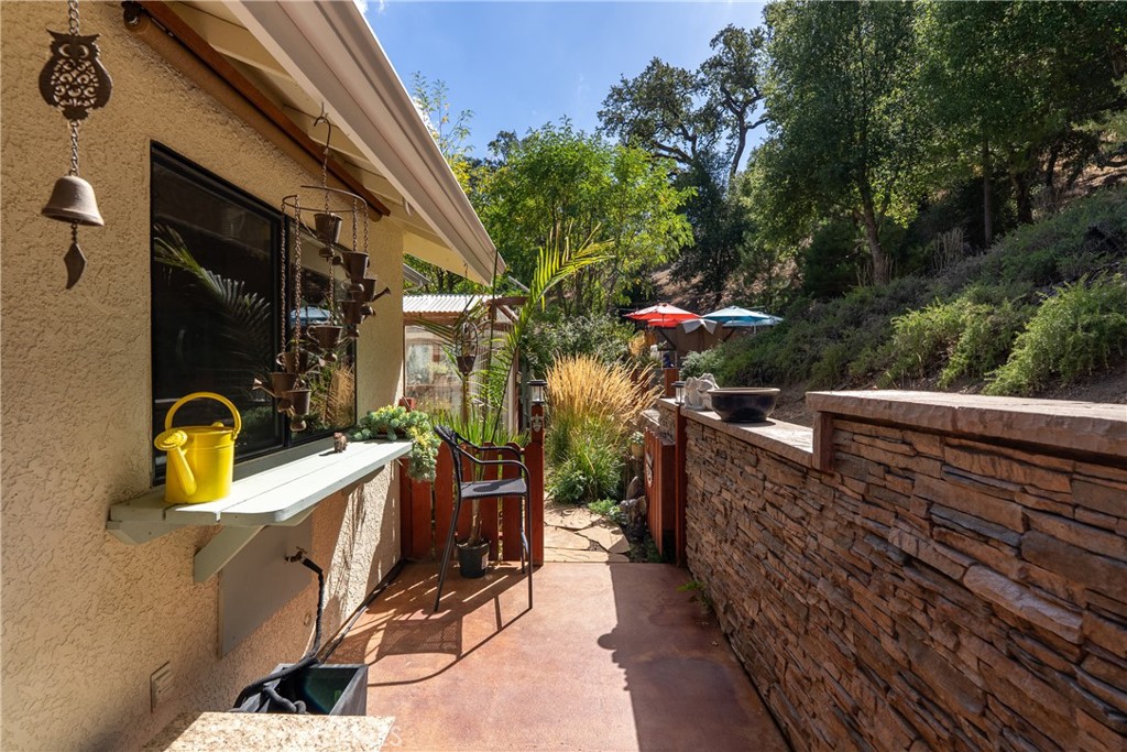 11625 Cenegal Road Atascadero, CA 93422 - Photo 44 of 65 The patio area behind the home has stained concrete and a stacked stone looking wall.