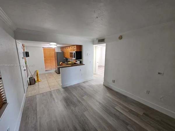 a view of a kitchen with wooden floor and electronic appliances