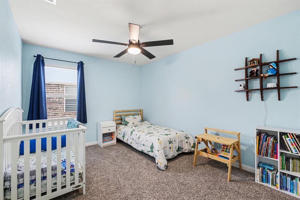 706 Spur Ridge Princeton, TX 75407 - Photo 25 of 38 a bedroom with a bed and a book shelf