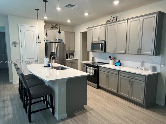 a kitchen with a sink refrigerator and cabinets