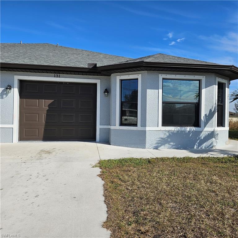 131 Gilbert Avenue South Lehigh Acres, FL 33973 - Photo 2 of 13 a house with yard in front of it