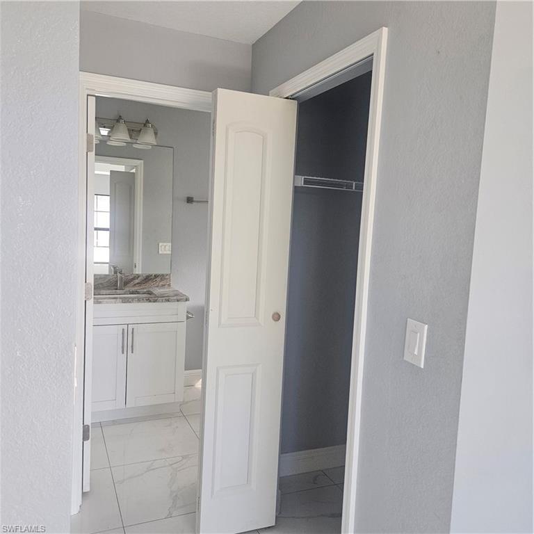 131 Gilbert Avenue South Lehigh Acres, FL 33973 - Photo 6 of 13 a bathroom with a granite countertop sink and a mirror