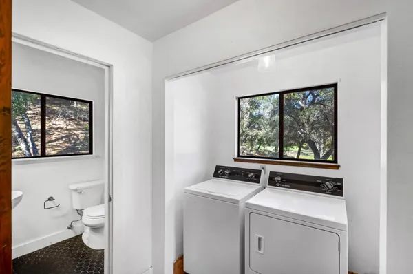 a bathroom with a toilet sink and large window