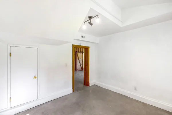 an empty room with a ceiling fan and a window