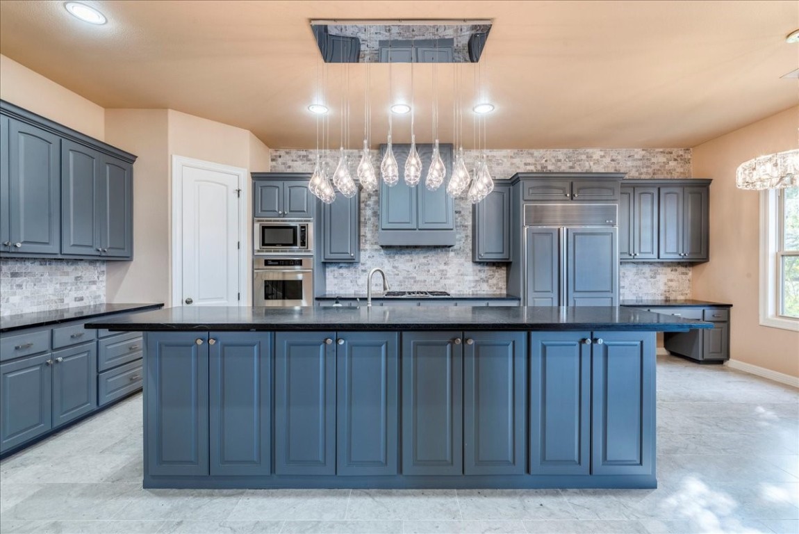 a kitchen with granite countertop a stove and cabinets