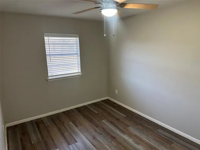 a view of a room with wooden floor and fan