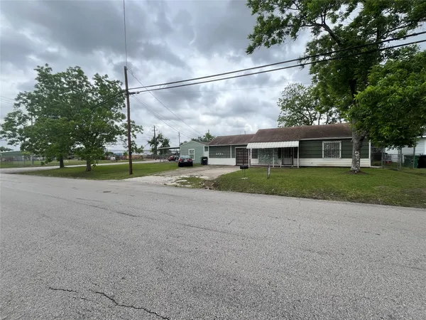 a view of a house with a big yard and large trees